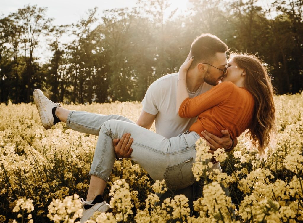 couple kissing on a flower field