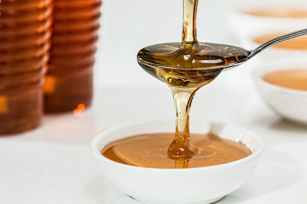 pouring honey on a white bowl