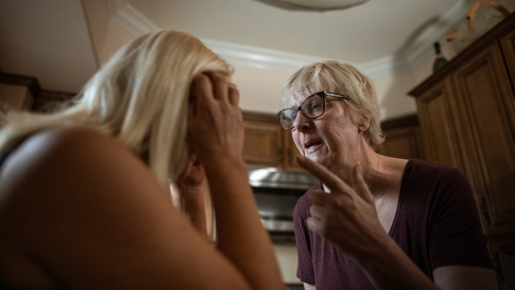 old woman pointing fingers to a blonde woman